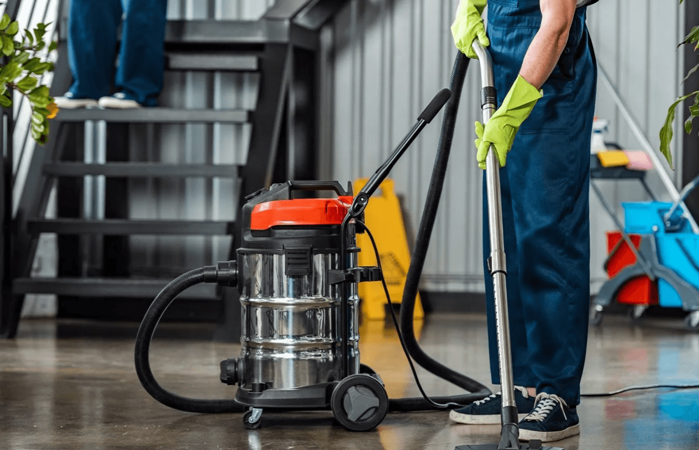 a cleaning professional wearing protective gloves while wiping a window in a well-lit office space, representing comprehensive cleaning business insurance offered by Powell Ohio Insurance Company to protect commercial cleaning businesses against potential risks and liabilities.